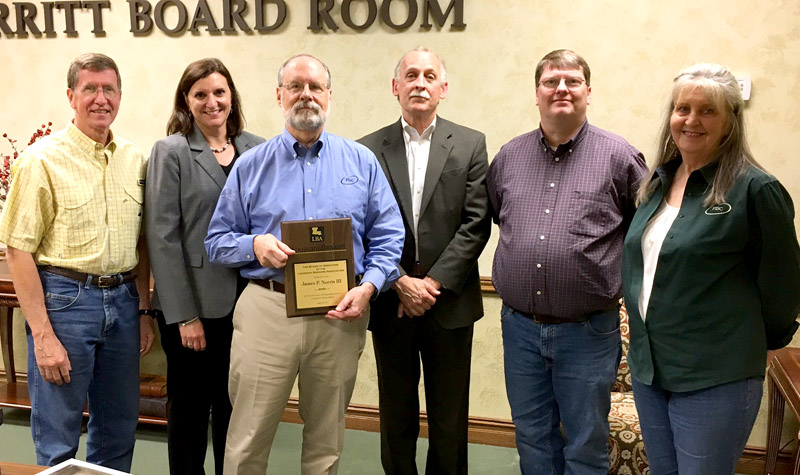 (third from left) FISC's Jim Norris receives a LBA Service Award on his retirement after 42 years of service to the banking industry. Also pictured (remaining, from left) are Pat Spencer of FISC,  LBA Chief Operating Officer Ginger Laurent, LBA Chief Executive Officer Robert Taylor, Greg Souther of FISC and Barbara Butler of FISC.